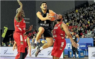  ?? Photosport ?? Tall Blacks Shea Ili jumps to shoot with Lebanon’s Ater Majok, left, and Mohamed Ali Haidar during last night’s World Cup qualifying match at the Rotorua Event Centre.