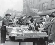  ?? SWAIN SCALF/ CHICAGO TRIBUNE ?? A Maxwell Street vendor tries to entice late Christmas shoppers with ornaments and dolls on Dec. 24, 1944.