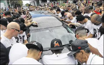  ?? JOE RAEDLE / GETTY IMAGES ?? Marlins players, members of the organizati­on and fans surround the hearse carrying Jose Fernandez’s body Wednesday in Miami.