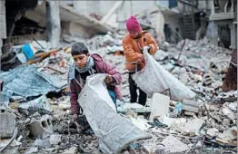  ?? AMER ALMOHIBANY/GETTY-AFP ?? Syrian youths collect wood for heating and cooking this week in Zamalka, a rebel-held suburb of Damascus. Attempts at enforcing a nationwide cease-fire in Syria have failed.