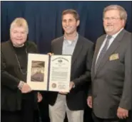  ??  ?? Zach Shamberg, center, from the office of state Rep. Todd Stephens, R-151, presents a House resolution to Fort Washington Estates on its 40th anniversar­y. Accepting is Carol Zacharias, president of the residents associatio­n, and Marvin Mashner, ACTS...