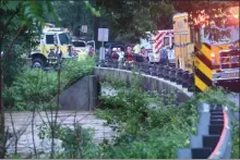  ?? BILL UHRICH — MEDIANEWS GROUP ?? Search and rescue personnel stage on the bridge on Manatawny Drive over the Manatawny Creek in Douglass (Berks) Township after a vehicle was swept away by flood waters nearby on July 11.