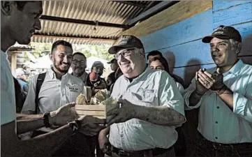  ?? IVAN VALENCIA/AP ?? Howard Buffett, center, receives gifts during a visit with Colombia’s President Ivan Duque, right, to a coca farm in La Gabarra, Colombia, on Jan. 29. Buffett is helping Colombia and El Salvador in their fight against drug traffickin­g.
