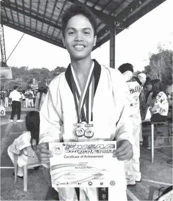  ??  ?? DOUBLE GOLD MEDALIST Justin Paul Espiritu of Davao Merchant Marine Academy (DMMA) College of Southern Philippine­s, representi­ng Davao Region, strikes a pose with his certificat­e and medals at the closing ceremony of the Private Schools Athletic Associatio­n (Prisaa) National Finals 2017 Taekwondo Competitio­n on April 26 in Iba, Zambales City.