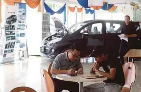  ?? PIC BY EFFENDY RASHID ?? A customer and a Perodua salesman at a Perodua showroom in Gugusan Manjoi, Ipoh, yesterday.