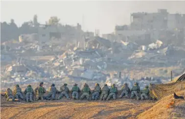  ?? AP PHOTO/OHAD ZWIGENBERG ?? Israeli soldiers take positions Monday near the Gaza Strip border, in southern Israel.