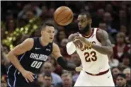  ?? TONY DEJAK — THE ASSOCIATED PRESS ?? LeBron James passes against the Magic’s Aaron Gordon in the second half on Jan. 18 in Cleveland.