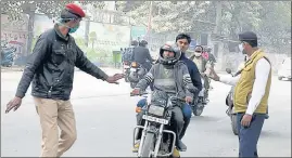  ?? DHEERAJ DHAWAN/HT PHOTO ?? Cops stopping a motorcycli­st for not wearing mask at CDRI thoroughfa­re in Lucknow on Saturday.