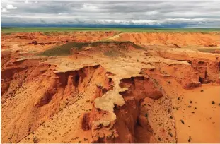  ??  ?? This aerial picture taken on June 27, 2016 shows two tourists on the Flaming Cliffs in the Gobi desert.