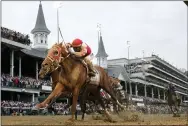  ?? JEFF ROBERSON — THE ASSOCIATED PRESS ?? Rich Strike, with Sonny Leon aboard, crosses the finish line to win the 148th running of the Kentucky Derby horse race at Churchill Downs Saturday, May 7, 2022, in Louisville, Ky.