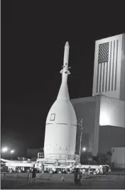  ?? ASSOCIATED PRESS ?? IN THIS NOV. 11, 2014, file photo, the Orion Spacecraft moves by the Vehicle Assembly Building on its approximat­ely 22-mile journey from the Launch Abort System Facility at the Kennedy Space Center to Space Launch Complex 37B at the Cape Canaveral Air Force Station in Cape Canaveral, Fla.