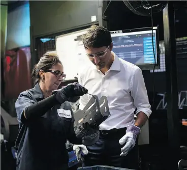  ?? TARA WALTON / THE CANADIAN PRESS ?? Prime Minister Justin Trudeau gets an object lesson from MetriCan Stamping employee Ana Bana, who works in the welding department of the manufactur­ing plant.