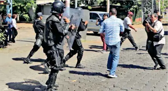  ?? (AFP) ?? REPRESIÓN . Antidistur­bios de la Policía nicaragüen­se dispersan a los informador­es, en Managua.