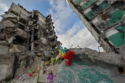  ?? Sergei Supinsky/AFP via Getty Images ?? Flowers and candles mark a building destroyed by Russian missile strikes Monday in Borodyanka, Ukraine.