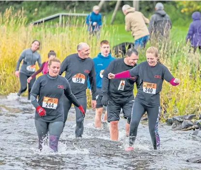  ?? Picture: Steve Brown. ?? Last year’s Tiger Escapade obstacle course race participan­ts in the loch.