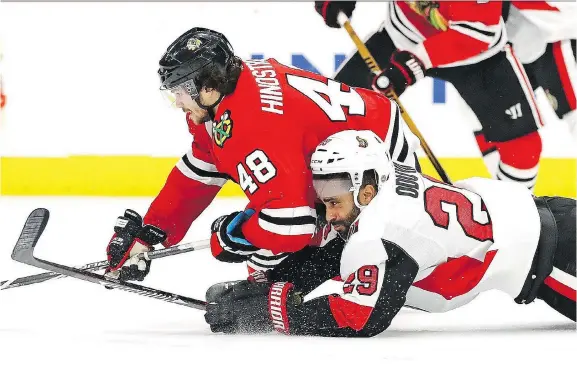  ?? JONATHAN DANIEL/GETTY IMAGES ?? Ottawa defenceman Johnny Oduya fights for the puck with Vinnie Hinostroza of the Blackhawks at Chicago’s United Center on Wednesday night. The Senators suffered their fifth straight loss, a 3-2 setback to the Blackhawks in a battle of two teams that...