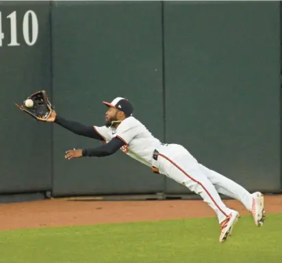  ?? KENNETH K. LAM/BALTIMORE SUN ?? Orioles center fielder Cedric Mullins makes a diving catch to rob Minnesota’s Kyle Farmer of a hit in the first inning Monday night in Baltimore.