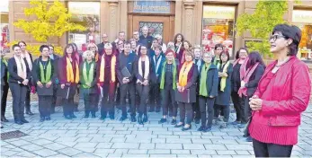  ?? FOTO: RAPP-NEUMANN ?? Vor dem Haus Zimmerle, dem früheren Gasthof Zum Schwarzen Adler und der heutigen Adler-Apotheke, singt der Chor eine kleine Nachtmusik frei nach Mozart. Rechts Stadtführe­rin Ruth Julius.