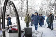  ?? SERGEI GAVRILENKO / AP ?? Kemerovo Governor Sergei Tsivilyov (center left) and Russian Deputy Prosecutor General Dmitrii Demeshin (center) lay flowers at the memorial to honour fallen rescuers in Siberia, Russia, Friday.