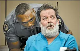  ?? ANDY CROSS/THE DENVER POST ?? A sheriff’s deputy talks to suspect Robert Dear during a court appearance Wednesday in Colorado Springs, Colo. Dear, 57, made several outbursts before being formally charged.