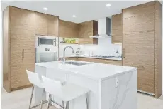  ??  ?? The kitchens at The Parker feature square-edged quartz countertop­s.