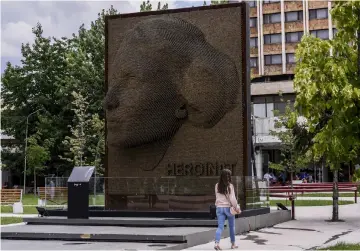  ?? — AFP photos by Armend Nimani ?? A woman walks past a monument entitled “Heroines” honouring the contributi­on and sacrifice of every ethnic Albanian woman during the 1998-1999 war in Kosovo, in Pristina, on July 26, 2018.