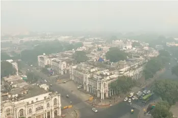  ?? SHONAL GANGULY/AP ?? Sooty blanket: Smog obscures the horizon on Friday in New Delhi, India. Authoritie­s there shut down factories and constructi­on sites, restricted diesel-burning vehicles and deployed water sprinklers and anti-smog guns to control the haze. India’s environmen­t minister blamed crop waste burning in the northern Punjab state for the conditions.