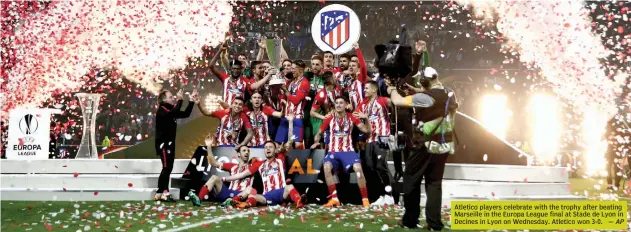  ?? — AP ?? Atletico players celebrate with the trophy after beating Marseille in the Europa League final at Stade de Lyon in Decines in Lyon on Wednesday. Atletico won 3- 0.