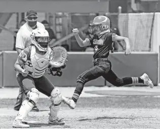  ?? Ronald Cortes / Contributo­r ?? New Braunfels Canyon’s Haley Carmona scores in the sixth inning as Southwest Legacy catcher Alyssa Pena waits for the throw. The Cougarette­s blew open Saturday’s game with five runs in the frame.