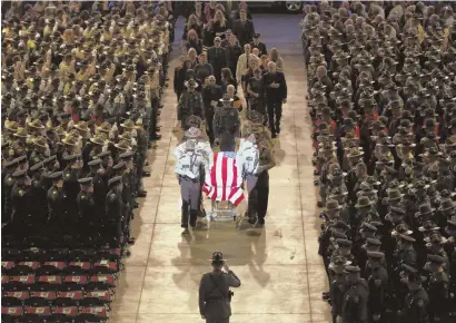  ?? AP PHOTOS ?? FAREWELL: The Maine State Police Color Guard, top, marches to the funeral of Cpl. Eugene Cole in Bangor, Maine, yesterday. Pallbearer­s escort the casket at the service, above. Left, the casket rests next to the sheriff deputy’s cruiser, as hundreds of...