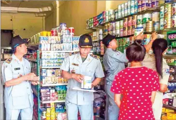  ?? CCF ?? Officials inspect Nutrilatt powdered milk formula in Kratie province. The formula was found to have deficient levels of iron.