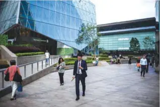  ??  ?? HONG KONG: People walk outside the Hong Kong Stock Exchange building in Hong Kong. A long-delayed trading link between the Shenzhen and Hong Kong stock markets will open December 5, regulators said yesterday opening up the mainland’s tech shares to...