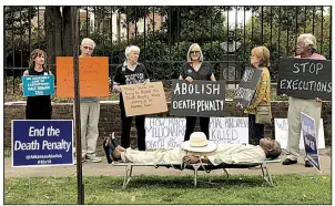  ?? Sherry Simon via AP ?? Pulaski County Circuit Judge Wendell Griffen lies on a cot in the role of a condemned prisoner awaiting execution during a protest outside the Governor’s Mansion in April 2017. Almost simultaneo­usly, he issued an order blocking the use of a component of the state’s lethal-injection drugs.