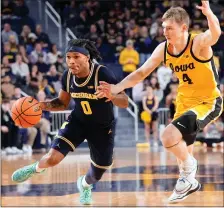  ?? CARLOS OSORIO —THE ASSOCIATED PRESS ?? Michigan guard Dug McDaniel (0) drives as Iowa guard Josh Dix (4) defends during the second half of Saturday’s game in Ann Arbor.