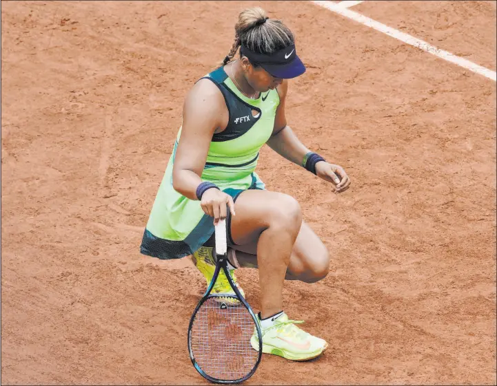  ?? Christophe Ena The Associated Press ?? Naomi Osaka stretches her left foot during a first-round loss to Amanda Anisimova at the French Open on Monday. Osaka’s impact on mental health concerns in tennis are still resonating a year after she withdrew from the French Open. Players credit her with making admissions of mental health issues acceptable in tennis, and beyond.
