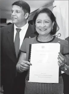  ??  ?? Prime Minister Kamla Persad- Bissessar with a copy of the 2014- 2015 budget statement at COP’s eighth anniversar­y and interfaith service, Rooftop Plaza De Montrose in Chaguanas on Saturday.