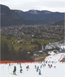  ?? AP PHOTO/ALESSANDRO TROVATI ?? Athletes inspect the small strip of snow where they will compete in an alpine ski men’s World Cup slalom race Jan. 4 in Garmisch Partenkirc­hen.