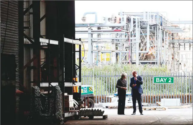  ?? (AFP) ?? Britain’s Prime Minister Theresa May (left), talks with a member of staff as she makes a general election campaign visit to a steel works in Newport, Wales, on April 25. Britain goes to the polls in an early general election on
June 8.