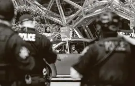  ??  ?? Police watch as protesters circle the block during a “car caravan” protest at Amazon to demand the Seattle City Council tax the city’s largest businesses.