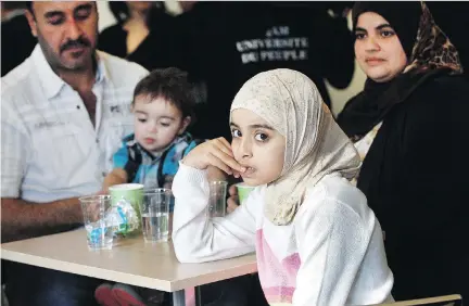  ?? MARIE-FRANCE COALLIER/FILES ?? Syrian refugee families gathered in December to mark the anniversar­y of the first chartered flight of Syrian refugees. Bassam Alamir, left, with his son Zaid, wife, Fater Nseirat, far right, and daughter Maria, 8, arrived in Quebec on Jan. 15 and now...