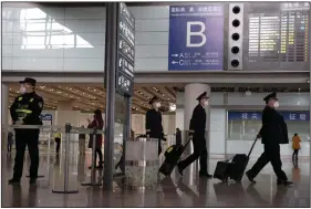  ?? (AP/Ng Han Guan) ?? In March, air crew members walk past the internatio­nal arrivals exit at the Capital Internatio­nal Airport in Beijing. President Donald Trump credits his February ban on travelers from mainland China as his signature move against the advance of the pandemic. More photos at arkansason­line. com/75travelba­n/