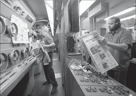  ?? Photograph­s by Natalie Behring Getty Images ?? JOHN SHAMROCK, left, and Derwin Williams check copies of the Columbian after they come off the presses in Vancouver, Wash.