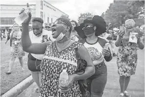  ??  ?? Charlene Davis sings as she waits in line to pay respect to George Floyd at The Fountain of Praise church in Houston. RICARDO B. BRAZZIELL/ AUSTIN AMERICAN- STATESMAN