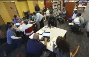  ?? The Associated Press ?? ENROLLMENT: In this photo Feb. 12 photo, Affordable Care Act navigators hold an enrollment event at the Fort Worth Public Library in Fort Worth, Texas. Nearly a million people signed up for health insurance under President Barack Obama's law even after...