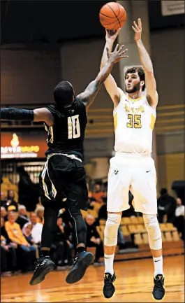  ?? KYLE TELECHAN/POST-TRIBUNE ?? Valparaiso forward Ryan Fazekas, right, shoots for 3 past Purdue Northwest guard Dean Tate on Saturday.