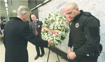  ?? — AFP ?? King Philippe of Belgium pays tribute to the victims of last year terrorist attacks in Brussels, at the remembranc­e wall in the Maelbeek — Maalbeek subway station.