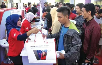  ?? FRIZAL/JAWA POS ?? PERKUAT PASAR: Konsumen Huawei Nova 2 Lite saat first sale di Plasa Marina Surabaya Sabtu (5/5).