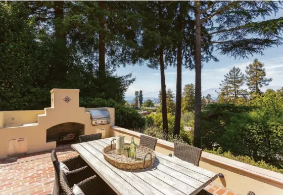  ?? LIZ_RUSBY ?? Above: The lower patio includes an outdoor fireplace and built-in barbecue. Below left: The lower level plays home to a media room with a fireplace. Below right: Hardwood flooring lines the kitchen, which includes a breakfast area.