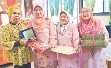  ??  ?? Jamilah (left) receiving a token of appreciati­on from Asmah as other Bistari members look on.