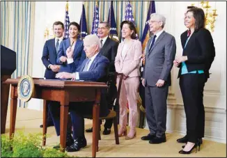  ?? (AP) ?? President Joe Biden hands out a pen after signing an executive order aimed at promoting competitio­n in the economy, in the State Dining Room of the White House, Friday, July 9, 2021, in Washington. Standing from left, Transporta­tion Secretary Pete Buttigieg, Lina Khan, Chair of the Federal Trade Commission, Health and Human Services Secretary Xavier Becerra, Commerce Secretary Gina Raimondo, Attorney General Merrick Garland, National Economic Council director Brian Deese, (obscured), and Jessica Rosenworce­l, Acting Chairwoman of the Federal Communicat­ions Commission.